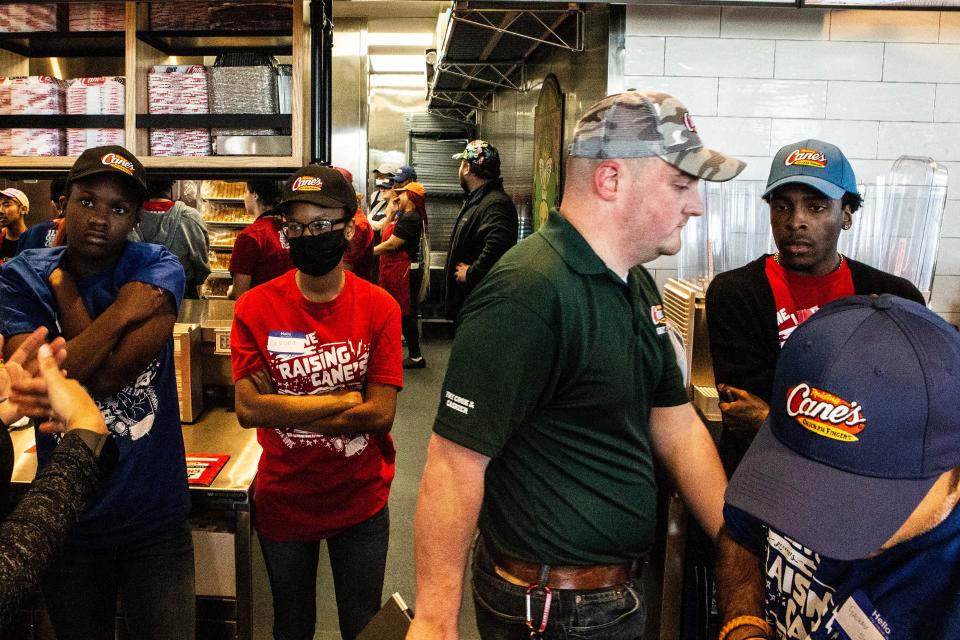 Trainees gather in the kitchen area of Raising Cane's at The Grove (formerly College Square shopping center) in Newark, Thursday, April 13, 2023.