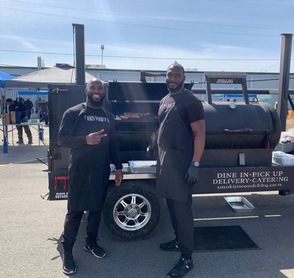 James Woodard, left, and brother Joshua are pictured in front of a Smokin Woods BBQ smoker. Several members of the family are involved in the business, which is planning a location in Fresno.