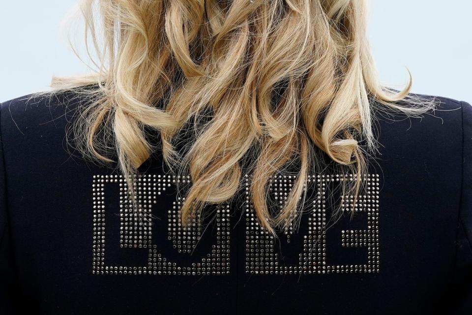 First lady Jill Biden turns around to show the word "LOVE" on the back of her jacket as she speaks with reporters after visiting with Carrie Johnson, wife of British Prime Minister Boris Johnson, ahead of the G7 summit, June 10, 2021, in Carbis Bay, England.