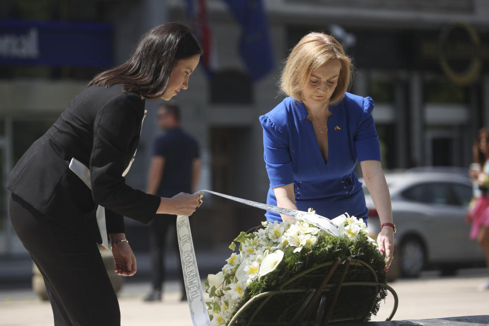 Elizabeth Truss Britain's Secretary of State for Foreign, Commonwealth and Development Affairs, right, lays a wreath together with the Mayor of Sarajevo Benjamina Karic at a monument dedicated to the children killed during Bosnian war in the besieged Bosnian capital in Sarajevo, Bosnia, Thursday, May 26, 2022. (AP Photo/Armin Durgut)