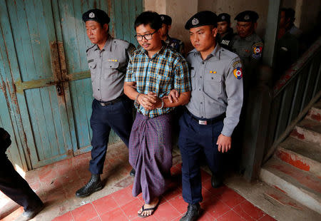 Detained Reuters journalist Wa Lone is escorted by police after a court hearing in Yangon, Myanmar February 28, 2018. REUTERS/Stringer