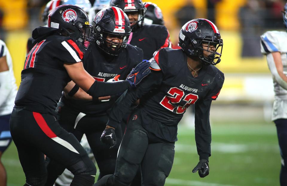 AliquippaÕs Tiqwai Hayes (23) celebrates scoring a touchdown with Cameron Lindsey (11) and Braylon Wilcox (53) during the first half of the WPIAL 4A Championship game against Central Valley Friday night at Acrisure Stadium in Pittsburgh, PA.