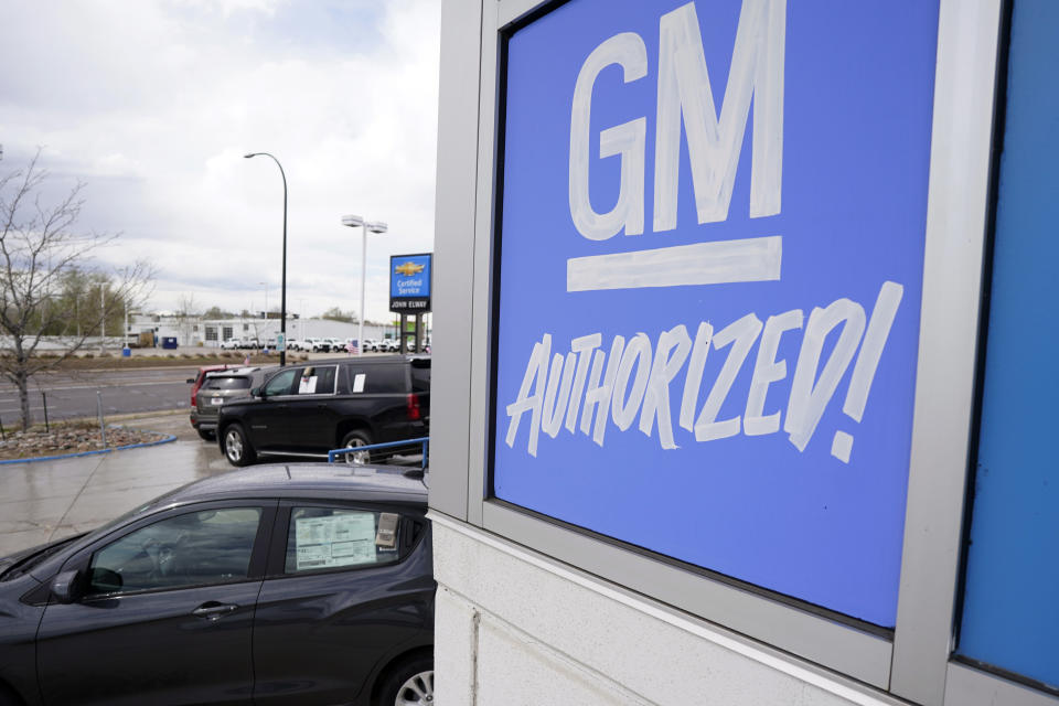 FILE- In this May 2, 2021, file photo, a General Motors sign hangs on the side of a Chevrolet showroom in Englewood, Colo. Michigan's economic development board on Tuesday, Jan. 25, 2022 approved $824 million in incentives and assistance for General Motors Co. to put electric vehicle and battery plants in its home state, adding as many as 4,000 jobs. (AP Photo/David Zalubowski, File)