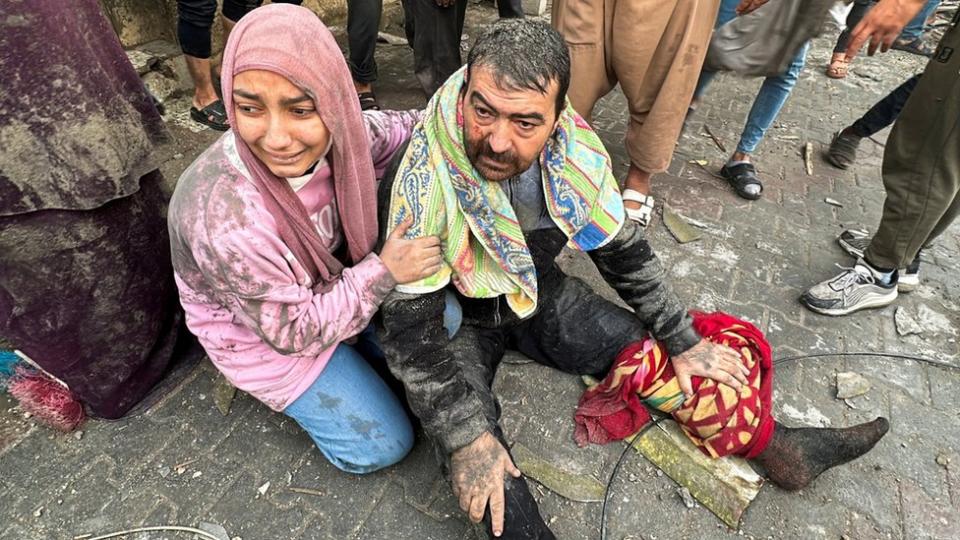 A woman cries as she hugs an injured man after an Israeli air strike on Rafah, southern Gaza. Photo: 12 December 2023