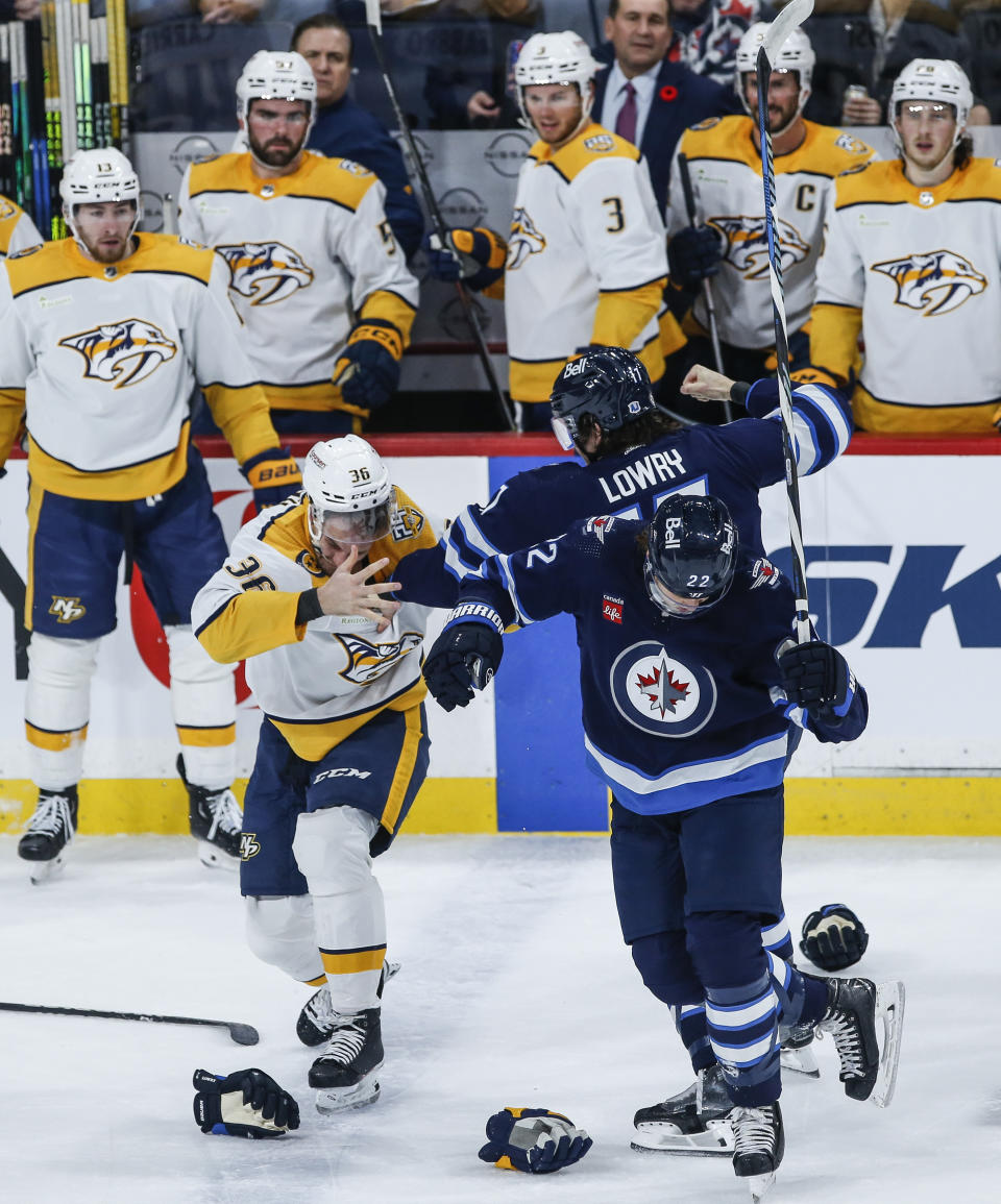 Winnipeg Jets' Mason Appleton (22) becomes entangled in a fight between Jets' Adam Lowry (17) and Nashville Predators' Cole Smith (36) during first-period NHL hockey game action in Winnipeg, Manitoba, Thursday, Nov. 9, 2023. (John Woods/The Canadian Press via AP)