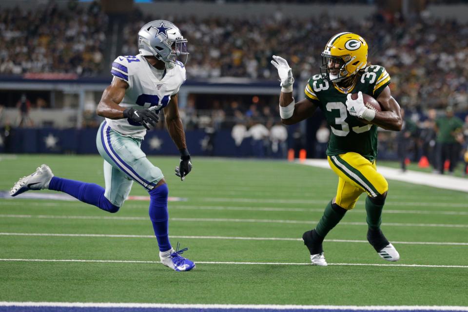 Aaron Jones waves to the Cowboys' 
Byron Jones en route to scoring a touchdown.