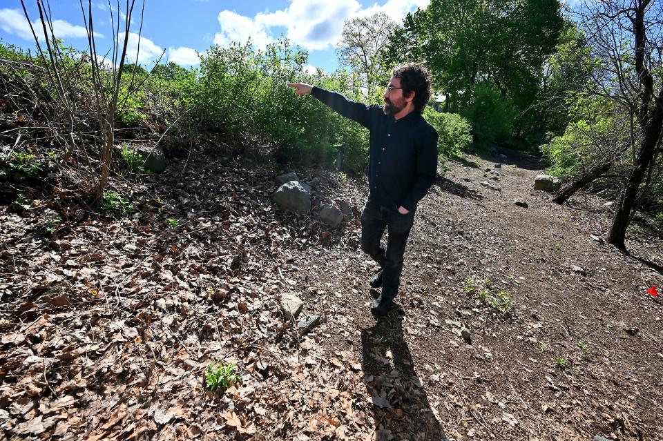 Jon Maynard of Chelmsford, who is leading the research investigation into a lost cemetery associated with the Lyman School for Boys on the shore of Lake Chauncy in Westborough, indicates where a receiving tomb's entrance is believed to be.