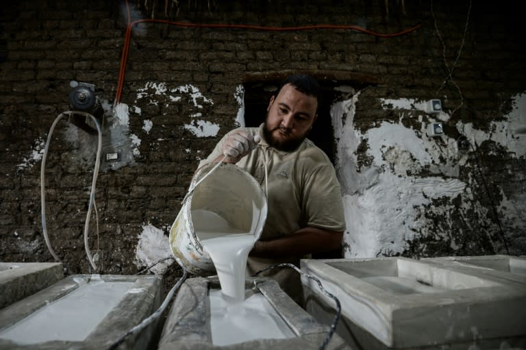 One of Mostafa el-Agoury's employees pours clay into a mould at Agoury's workshop in Egypt's Menufiya province on June 21, 2018