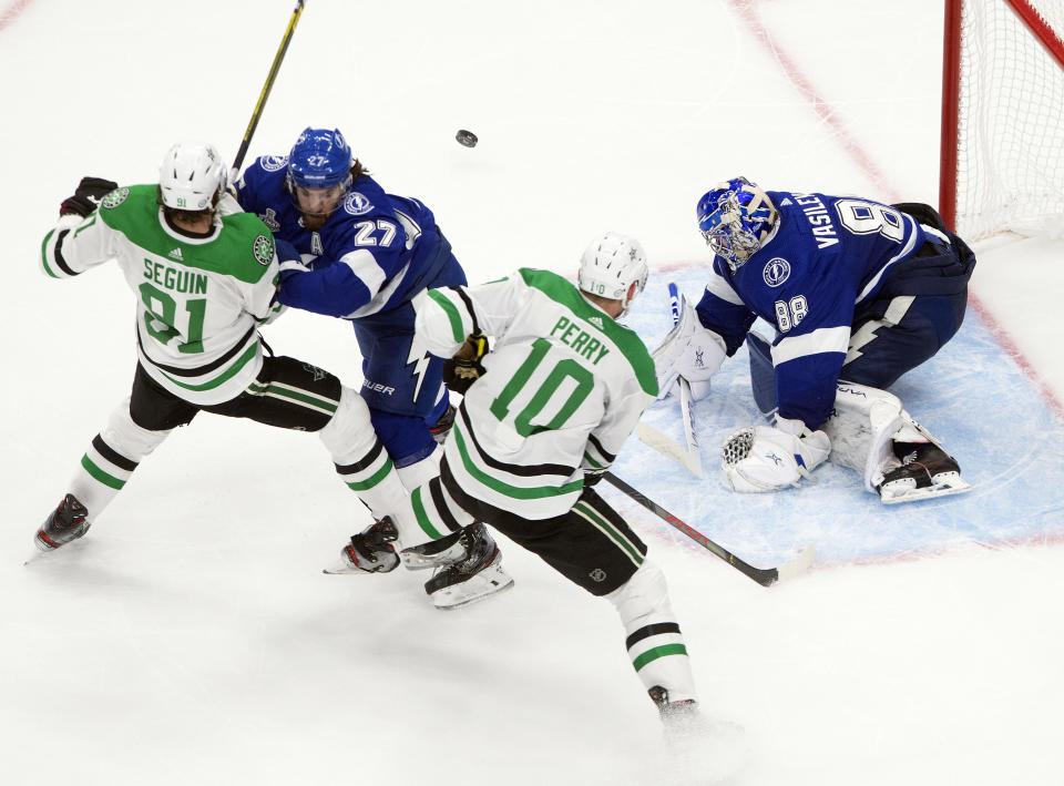 Dallas Stars' Tyler Seguin (91) and Corey Perry (10) battle Tampa Bay Lightning's Ryan McDonagh (27) as Lightning goalie Andrei Vasilevskiy (88) makes a save during third-period NHL Stanley Cup finals hockey action in Edmonton, Alberta, Monday, Sept. 21, 2020. (Jason Franson/The Canadian Press via AP)