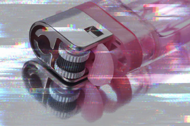 Close-up of a distorted, glitchy image of a lighter on a reflective surface