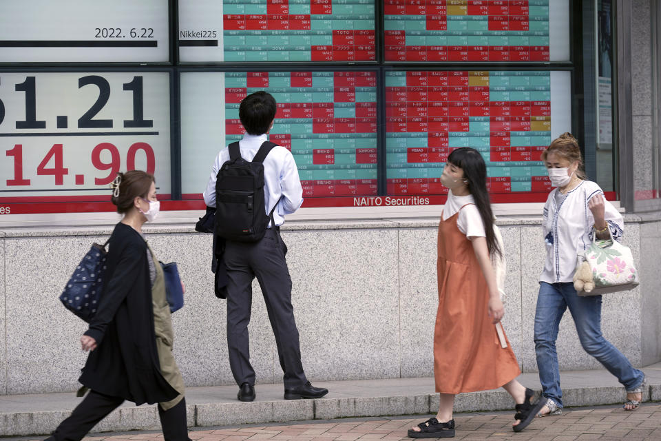 A man wearing a protective mask looks at an electronic stock board showing Japan's Nikkei 225 index at a securities firm Wednesday, June 22, 2022, in Tokyo. Asian shares were mostly lower Wednesday as markets shrugged off a Wall Street rally and awaited congressional testimony by Federal Reserve Chair Jerome Powell. (AP Photo/Eugene Hoshiko)