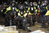 A demonstrator is arrested by police for violating curfew and an order to disperse during a protest against the police shooting of Daunte Wright, late Monday, April 12, 2021, in Brooklyn Center, Minn. (AP Photo/John Minchillo)