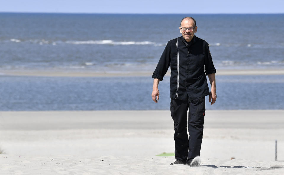 In this photo taken on Wednesday, May 15, 2019, Restaurateur Michael Recktenwald, who has taken legal action against the EU to protect climate walks on the beach near his restaurant, poses for the media on the car-free environmental island of Langeoog in the North Sea, Germany. Concerns about climate change have prompted mass protests across Europe for the past year and are expected to draw tens of thousands onto the streets again Friday, May 24. For the first time, the issue is predicted to have a significant impact on this week’s elections for the European Parliament. (AP Photo/Martin Meissner)