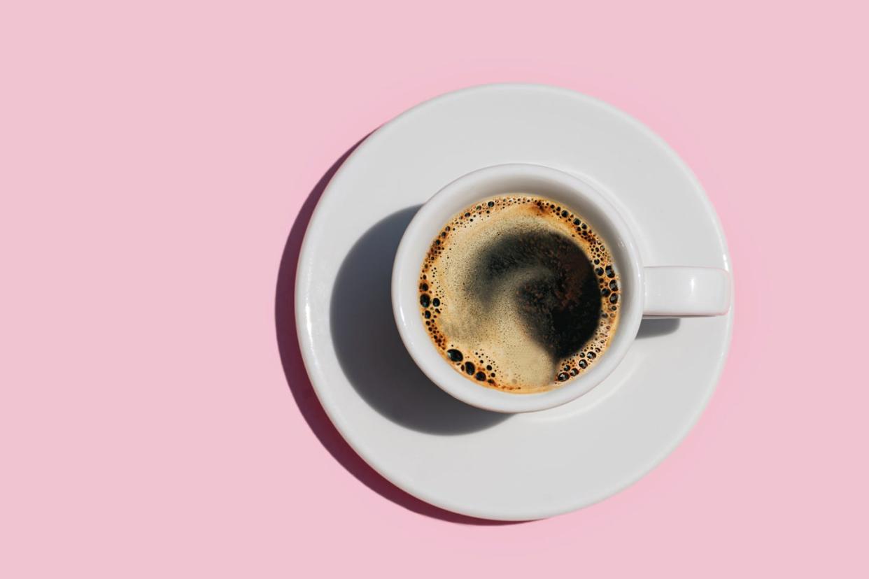 a shot of coffee on a pink background