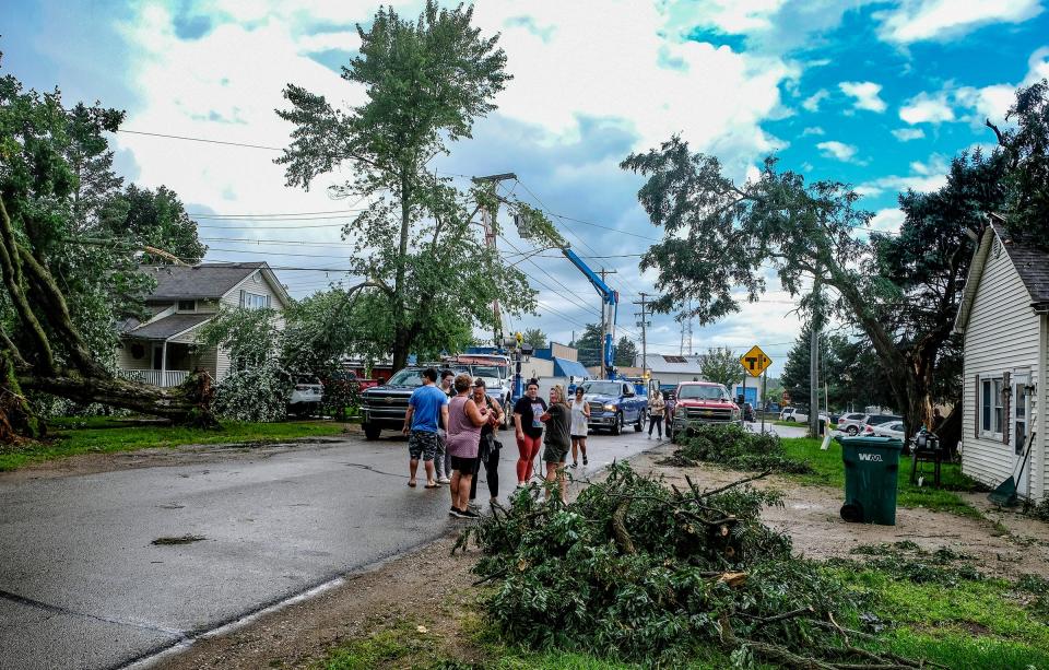 Residents of Perry watch as tornado damage is starting to be cleared Saturday, Aug. 12, 2023.