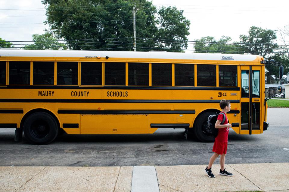 A child looks around the front of Riverside Elementary as a school bus drives by during the first day back to School in Columbia, Tenn. on Monday, Aug. 7, 2023.