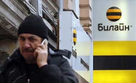 A man speaks on the phone near an office of Beeline, the brand owned by mobile phone operator Vimpelcom, in Moscow, November 12, 2014. REUTERS/Maxim Shemetov