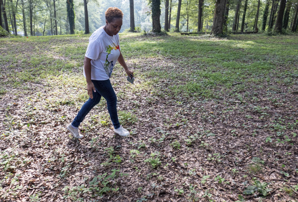 Ayisat Idris-Hosch walks through the Farmer Street Cemetery, a historic slave cemetery, in Newnan, Ga., on Monday, July 26, 2021, before a protest against a new skate park that is being built adjacent to the cemetery. Idris-Hosch said the city did not seek sufficient community input before beginning the project. (AP Photo/Ben Gray)