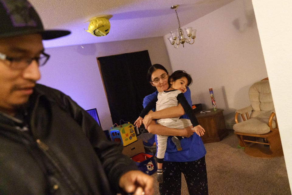 Georgianna Garbow-Warren, right, holds her son, Randy, Jr., 2, as her husband, Randy, Sr., leaves to work an overnight shift in Moorhead, Minn., Wednesday, Nov. 17, 2021. Because of an addiction to methamphetamine, Garbow-Warren lost custody of her older children. Her son turned 18 this year, the others are 17 and 10. She sometimes thinks about trying to track them down, but then wonders if they're better off without her. "I know I messed up, I know I did, and I wouldn't blame them if they don't want to see me," she said. "And I live with that everyday, wondering if they're OK." (AP Photo/David Goldman)