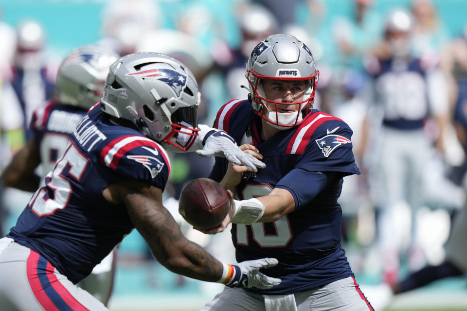 New England Patriots quarterback Mac Jones (10) hands off the ball to running back Ezekiel Elliott (15) during the first half of an NFL football game against the Miami Dolphins, Sunday, Oct. 29, 2023, in Miami Gardens, Fla. (AP Photo/Wilfredo Lee)