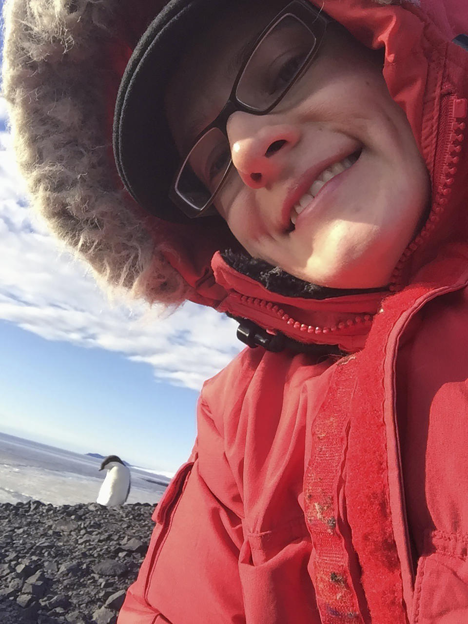 In this photo provided by Jennifer Sorensen, a Adelie penguin grooms itself behind Sorensen at McMurdo Station, Feb. 7, 2016. From Sunday, Oct. 1, 2023, workers at the main United States base in Antarctica will no longer be able to walk into a bar and order a beer, after the federal agency which oversees the research program on the ice decided to stop serving alcohol. (Jennifer Sorensen via AP)