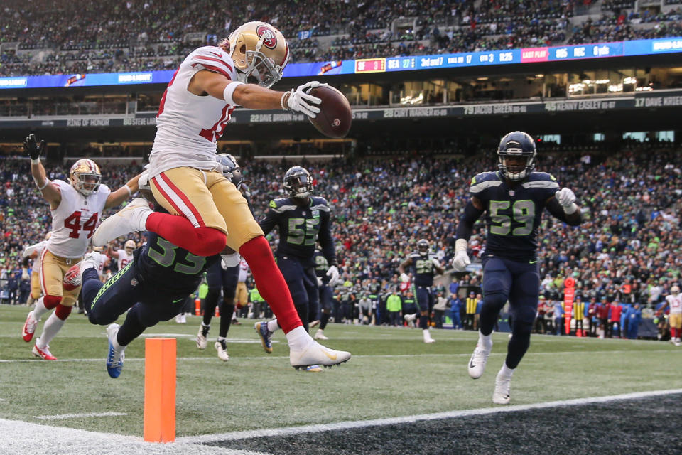 <p>Dante Pettis #18 of the San Francisco 49ers catches the ball over Tedric Thompson #33 of the Seattle Seahawks for a touchdown in the third quarter at CenturyLink Field on December 2, 2018 in Seattle, Washington. (Photo by Abbie Parr/Getty Images) </p>