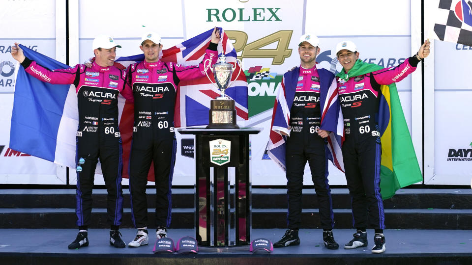 Winners of the Rolex 24 hour auto race, from left, Simon Pagenaud, of France, Oliver Jarvis, of Great Britain, Tom Blomqvist, of Monaco and Helio Castroneves, of Brazil celebrate in Victory Lane at Daytona International Speedway, Sunday, Jan. 30, 2022, in Daytona Beach, Fla. (AP Photo/John Raoux)