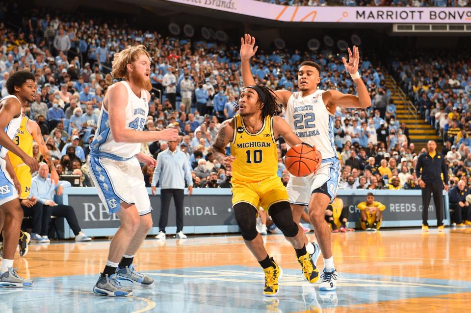 Michigan Wolverines guard Frankie Collins (10) with the ball as North Carolina Tar Heels forward Brady Manek (45) and forward Justin McKoy (22) defend in the first half at Dean E. Smith Center on Dec. 1, 2021.