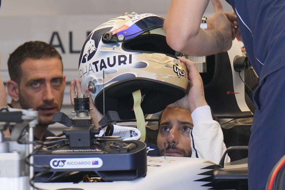 AlphaTauri driver Daniel Ricciardo of Australia puts on his helmet while sitting in his car before the Formula One U.S. Grand Prix auto race at Circuit of the Americas, Friday, Oct. 20, 2023, in Austin, Texas. (AP Photo/Nick Didlick)