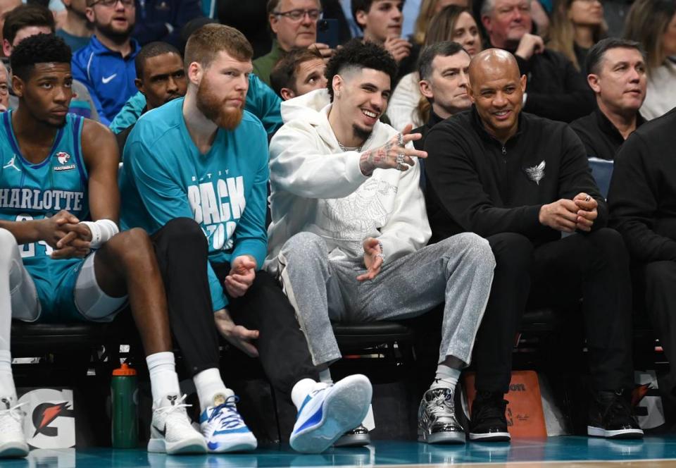 Injured Charlotte Hornets guard LaMelo Ball, center, smiles as he points out to the lane during first half action against the Milwaukee Bucks at Spectrum Center in Charlotte, NC on Thursday, February 29, 2024. JEFF SINER/jsiner@charlotteobserver.com