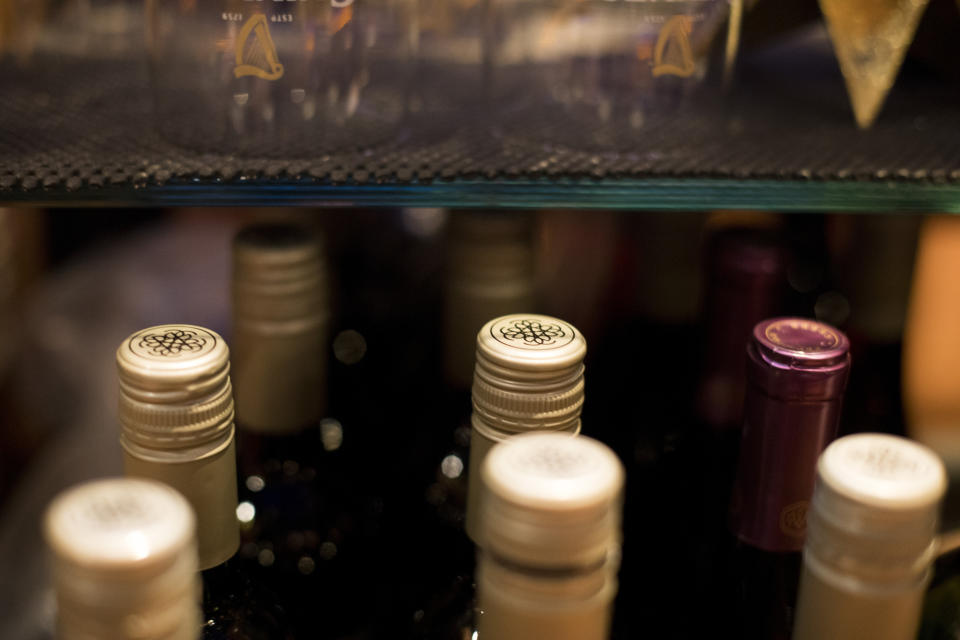 This Dec. 25, 2018, photo shows wine bottles at the bar at a bowling alley in Eagle, Colo. No one expects consumers to completely abandon Bordeaux wine from France, Scotch whisky or cheeses like Stilton, Roquefort when the tariffs take effect Friday, but retailers as well as their importers and distributors are aware that buying habits may change if shoppers fear they’re now paying 25% more for their favorite drinks and delicacies. (AP Photo/Jenny Kane)