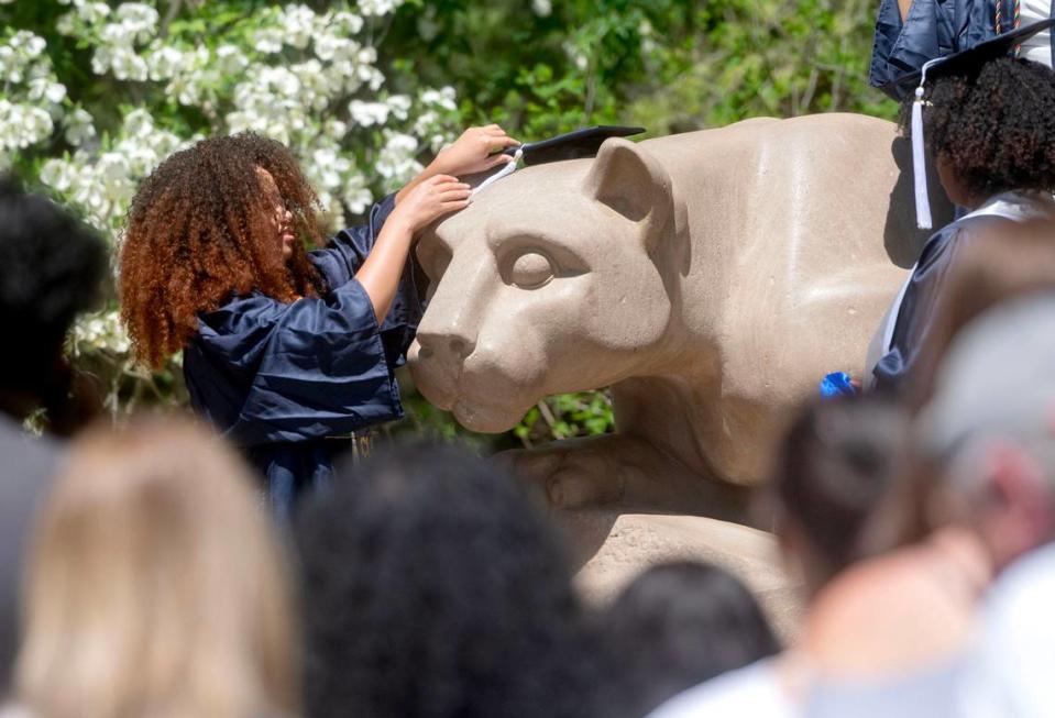 Soon-to-be Penn State graduates place a cap on the Nittany Lion on Wednesday, May 1, 2024. Abby Drey/adrey@centredaily.com