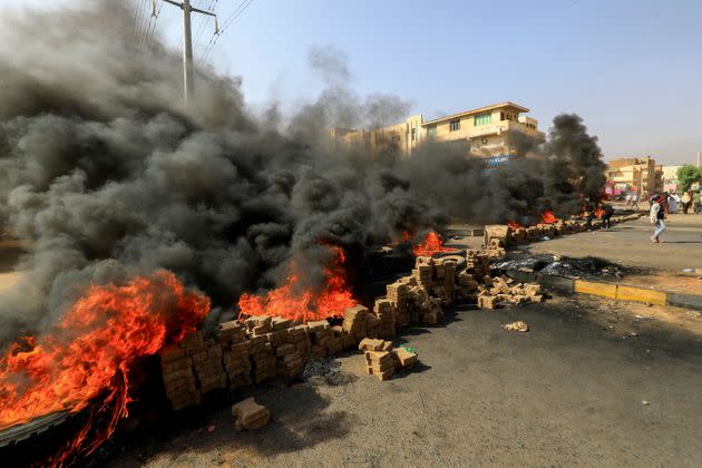 TOPSHOT - Sudanese protesters use bricks and burning tyres to block 60th Street in the capital Khartoum, to denounce overnight detentions by the army of members of Sudan's government, on October 25, 2021. - Armed forces detained Sudan's Prime Minister over his refusal to support their 