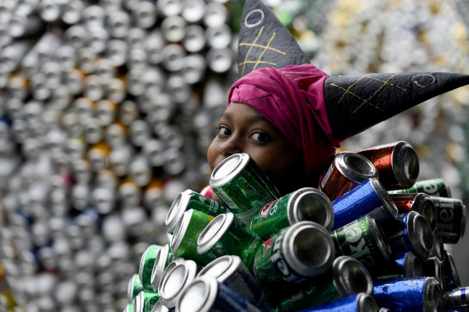 Una integrante del "Bloco da Latinha", con el característico traje hecho a base de latas de cerveza y refrescos, participa en el desfile de carnaval el domingo 11 de febrero de 2024, en Madre de Deus, Brasil. (AP Foto/Eraldo Peres)