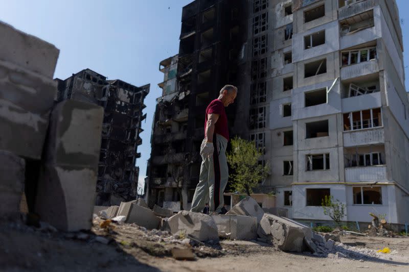 FILE PHOTO: Mykola Ovdienko collects rubble to rebuild his garage, after an airstrike destroyed a building near by, in Borodianka