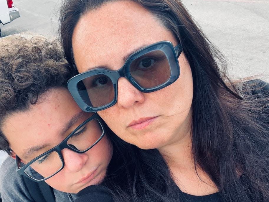Photograph of Flavia Hagan and her son looking sad.