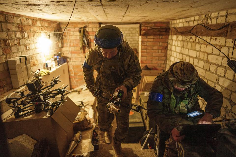 A Ukrainian serviceman of the ACHILLES battalion of the 92nd brigade carries a suicide drone to the position it will use to take off over Russian positions in the Kharkiv region of Ukraine on Sunday, May 12, 2024. (AP Photo/Evgeniy Maloletka)