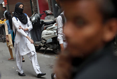 A Muslim school girl wearing hijab walks through a street in the old quarters of Delhi, India May 1, 2019. REUTERS/Adnan Abidi