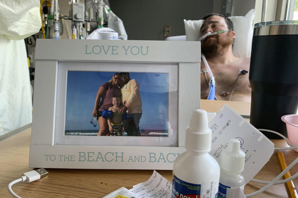 A framed photo of his family sits in front of Daryl Barker as he slowly recovers from COVID-19 inside Lake Regional Hospital's ICU in Osage Beach, Mo., on Monday, July 26, 20021. Barker had chosen not to be vaccinated against the virus but his long hospitalization has forced him to reconsider. (AP Photo/Sarah Blake Morgan)