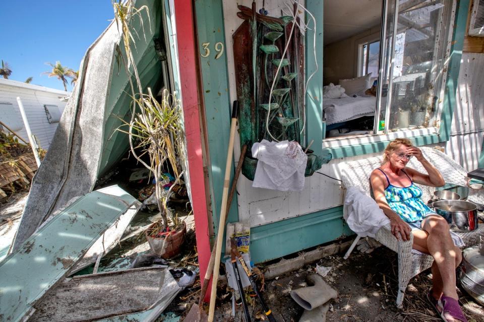 A woman sits outside her damaged home in Fort Myers Beach, Florida on Wednesday (EPA)