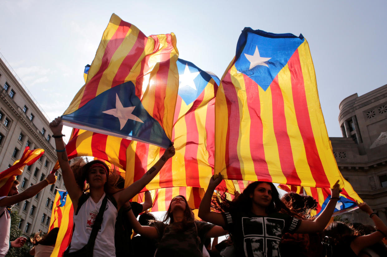 People hold on to Catalan separatist flags on top of an air vent during a demonstration two days after the banned independence referendum in Barcelona, Spain, October 3. (Photo: Enrique Calvo / Reuters)
