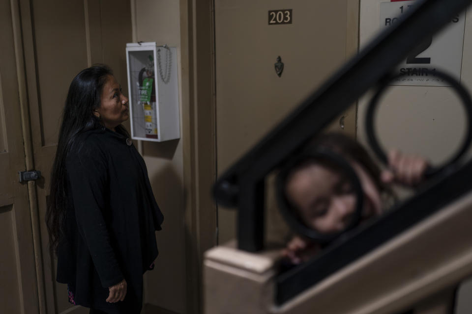 Deneffy Sánchez's mother, Lilian Lopez, stands outside her friend's apartment to ask to borrow her kitchen to cook for her daughter Jennifer in Los Angeles, Saturday, June 24, 2023. Pandemic job loss coupled with rising rents have pushed many California residents like Lopez and her family into desperate housing arrangements. (AP Photo/Jae C. Hong)