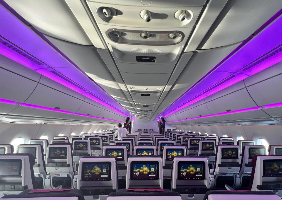 The economy seating on a Qatar Airways A350 viewed from the back, with all the screens on