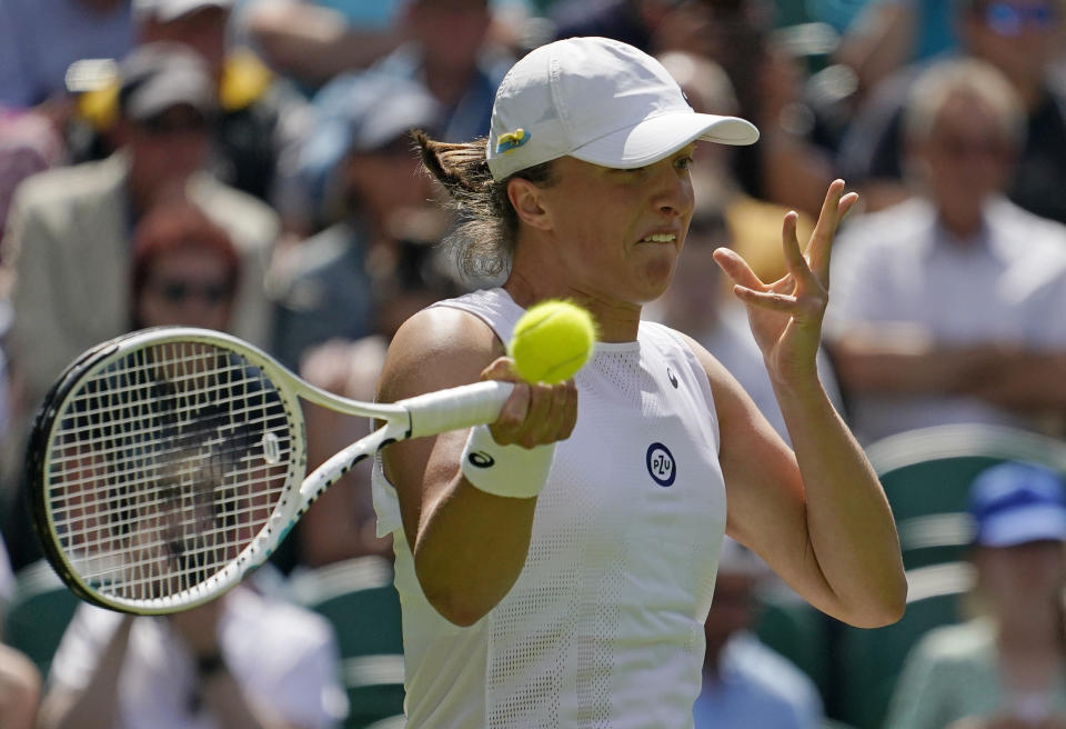 Poland's Iga Swiatek returns to Croatia's Jana Fett in a first round women's singles match on day two of the Wimbledon tennis championships in London, Tuesday, June 28, 2022. (AP Photo/Alberto Pezzali)