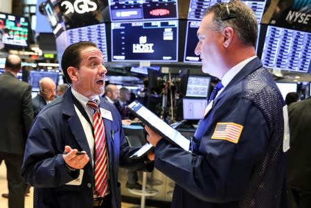 FILE PHOTO: Traders work on the floor at the NYSE in New York