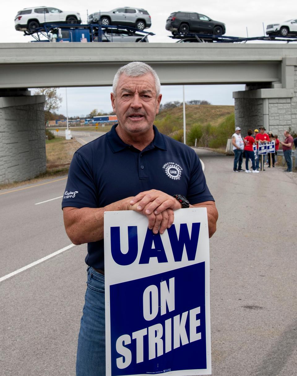 Tim Smith, UAW Region 8 director, pickets with other workers while a truck carrying multiple vehicles drives away from the General Motors plant in Spring Hill. UAW Local 1853 announced a strike in Spring Hill on Oct. 29 after 44 days of negotiations with GM.