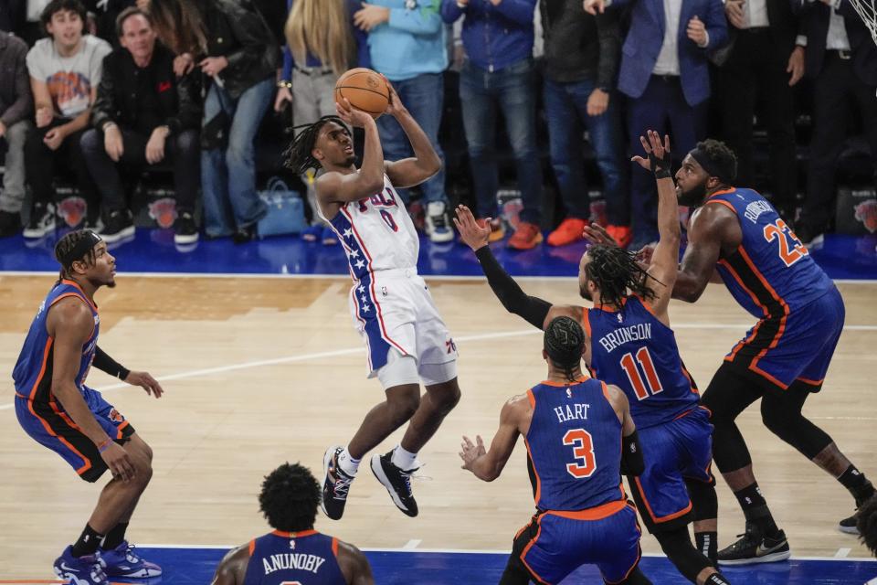 Philadelphia 76ers' Tyrese Maxey (0) shoots over New York Knicks' Jalen Brunson (11), Mitchell Robinson (23) and Josh Hart (3) during the second half of Game 5 in an NBA basketball first-round playoff series, Tuesday, April 30, 2024, in New York. The 76ers won 112-106 in overtime. (AP Photo/Frank Franklin II)