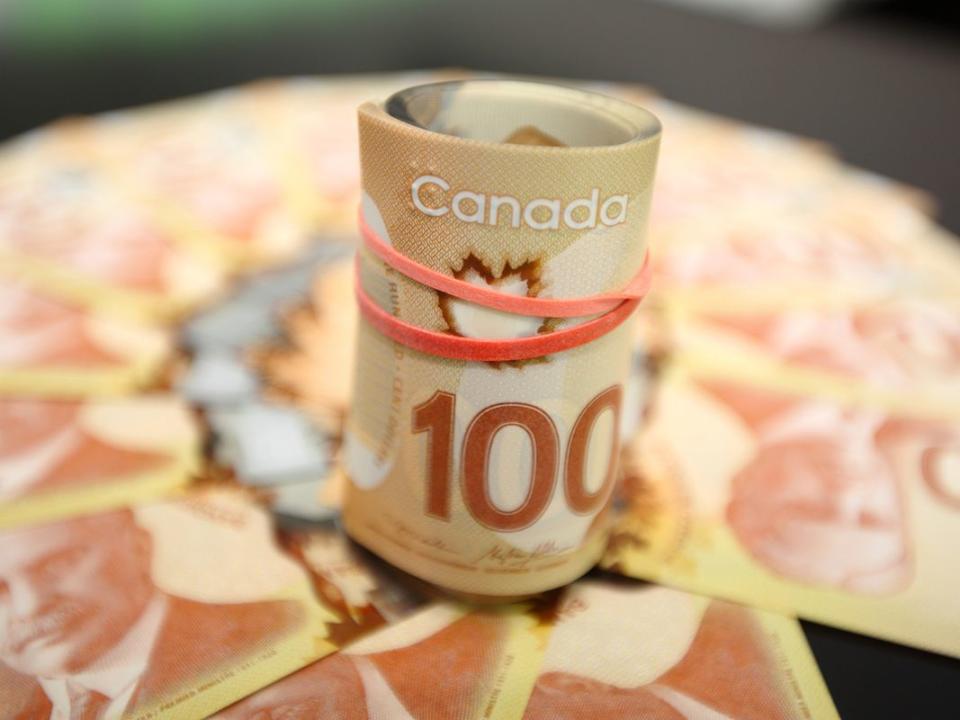 Canadian fanned hundred dollar bills and roll of bills