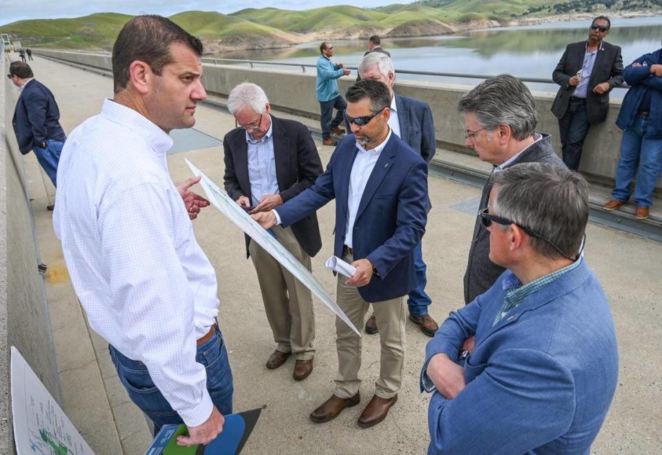 Congressman David Valadao, left, is joined by fellow Republicans Tom McClintock, second from left, and John Duarte, second from right, as well as Bruce Westerman, chairman of the House Committee on Natural Resources, Cliff Bentz, chairman of the House Subcommittee on Water, Wildlife and Fisheries, and Jason Phillips, center, CEO of the Friant Water Authority, as they discuss water storage on a tour on top of Friant Dam in Friant in April 2023. CRAIG KOHLRUSS/Fresno Bee file