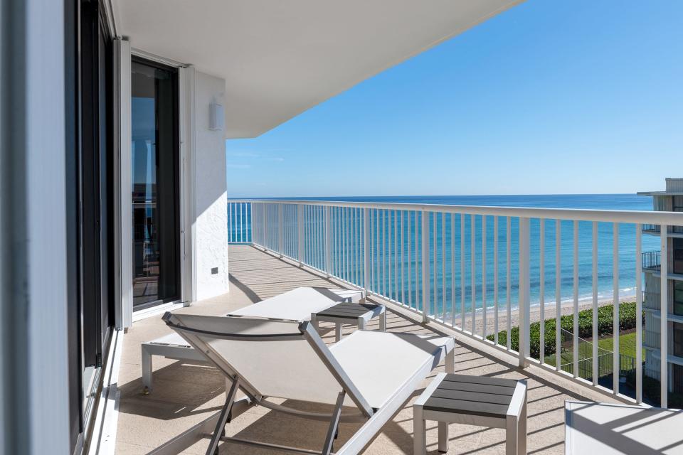 The balcony wraps around the south side of the apartment, where a lounge chair looks out to the Atlantic.